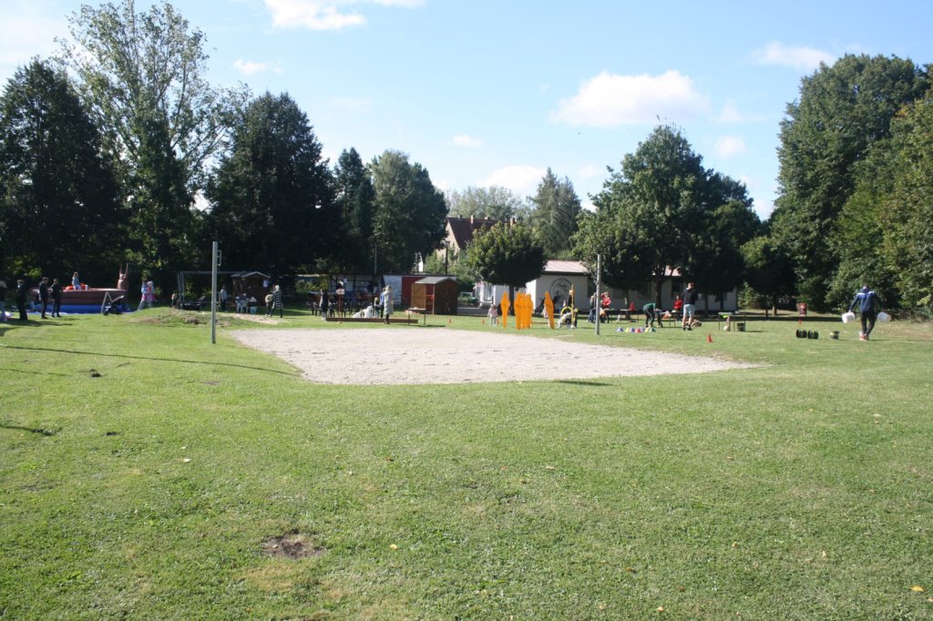 beachvolleyballfeld im Hintergrund sind Bäume zu sehen.